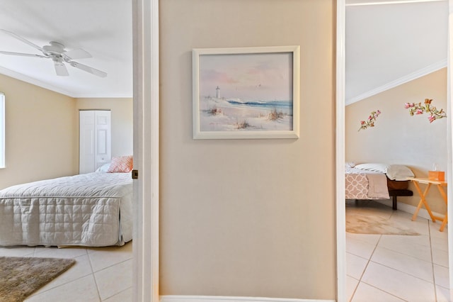 bedroom featuring a ceiling fan, tile patterned flooring, crown molding, and baseboards