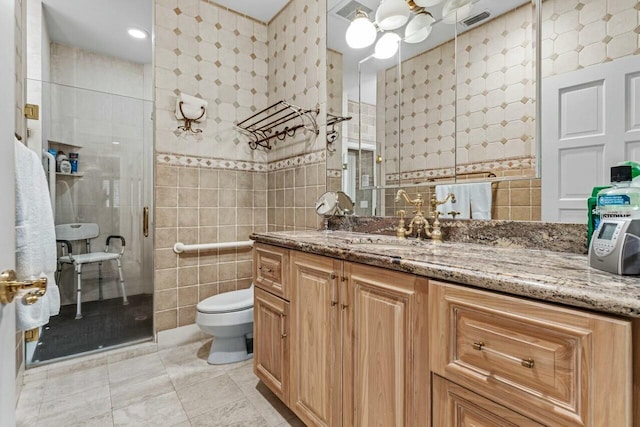 bathroom featuring vanity, toilet, tile walls, and a shower with shower door