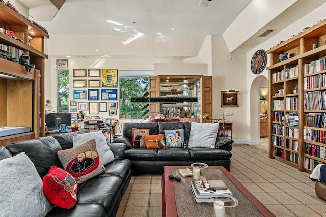 living room featuring built in shelves and light tile patterned floors