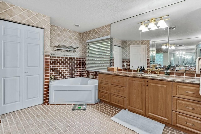 bathroom with vanity, plus walk in shower, and a textured ceiling