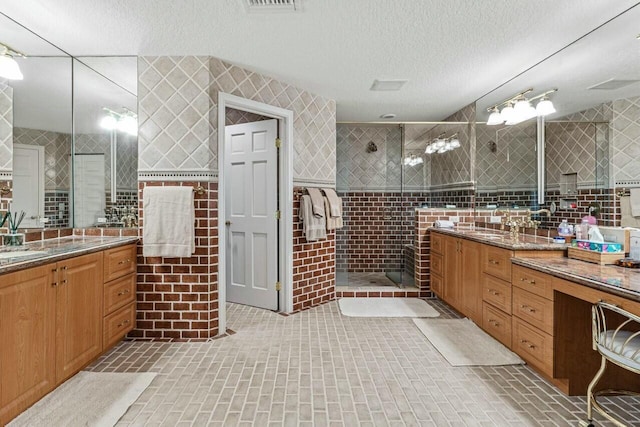 bathroom featuring vanity, a tile shower, and tile walls