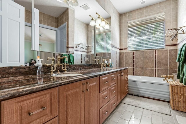 bathroom with vanity, a tub, tile walls, and tile patterned floors