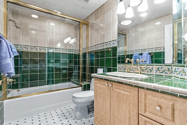 full bathroom featuring vanity, toilet, combined bath / shower with glass door, and tile walls