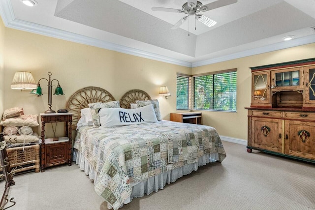 carpeted bedroom featuring crown molding, a tray ceiling, and ceiling fan