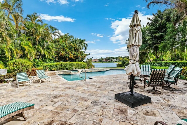 view of pool with a patio area, an in ground hot tub, and a water view