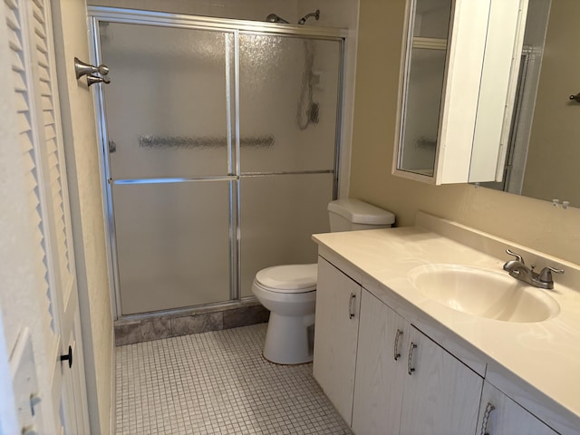 bathroom with tile patterned flooring, vanity, toilet, and an enclosed shower