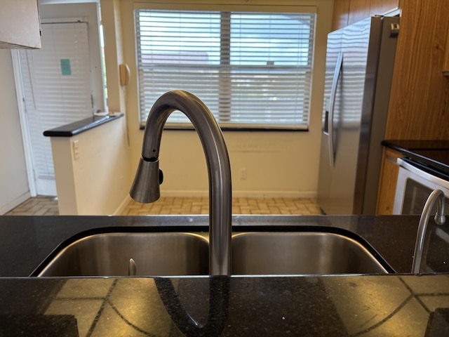 interior details featuring stainless steel fridge with ice dispenser and sink