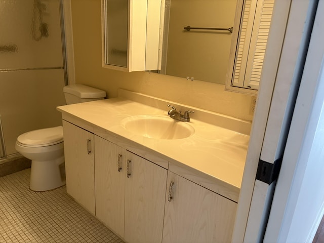 bathroom featuring vanity, toilet, and a shower with shower door