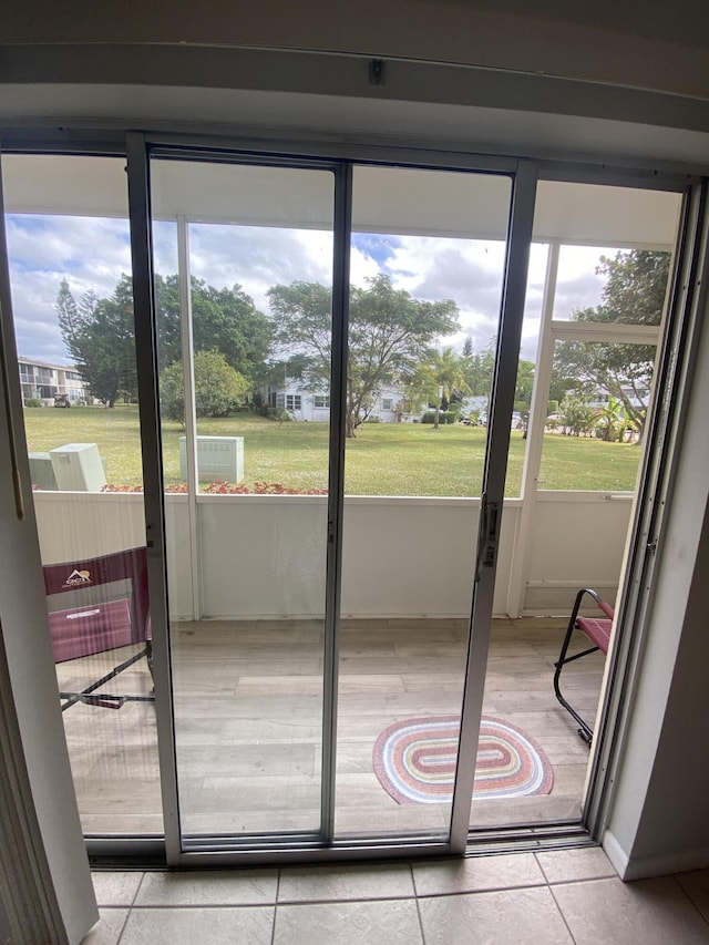 entryway with a wealth of natural light and light tile patterned flooring