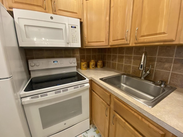 kitchen with white appliances, tasteful backsplash, and sink