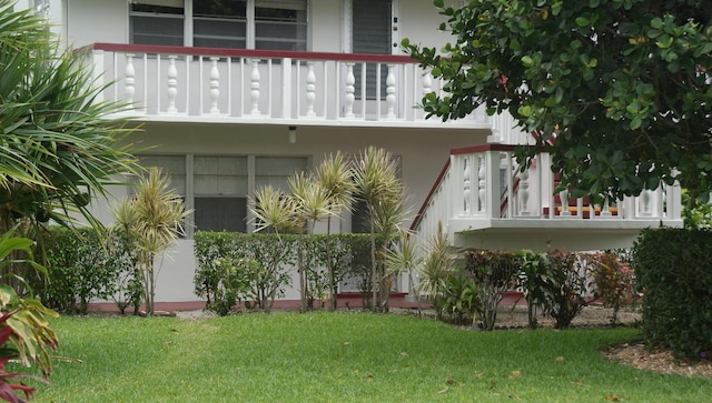 exterior space featuring a lawn and a balcony