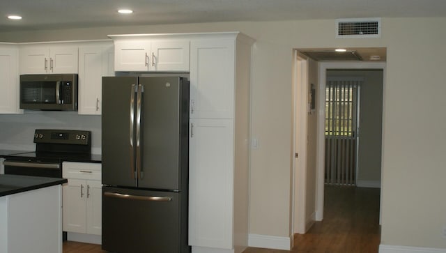 kitchen featuring white cabinetry, dark wood-type flooring, and appliances with stainless steel finishes