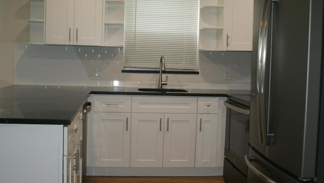 kitchen with decorative backsplash, appliances with stainless steel finishes, dark wood-type flooring, sink, and white cabinetry