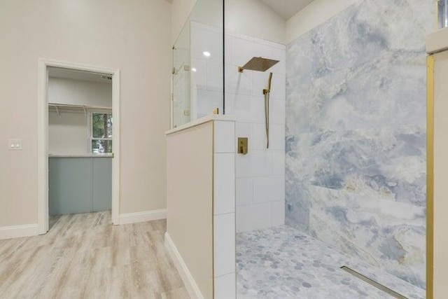 bathroom featuring hardwood / wood-style floors and tiled shower