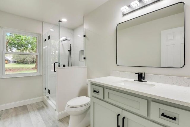 bathroom featuring hardwood / wood-style flooring, vanity, an enclosed shower, and toilet