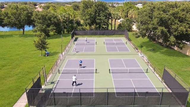 view of tennis court featuring a yard