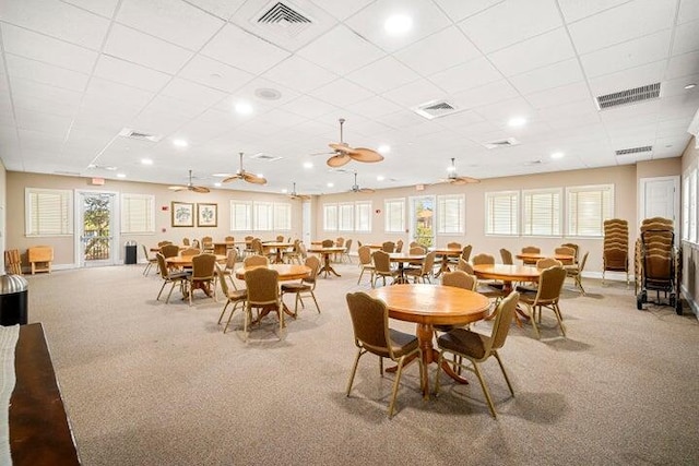 dining space featuring ceiling fan and light colored carpet