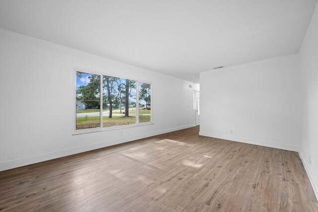 empty room featuring hardwood / wood-style floors and a notable chandelier