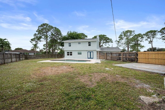 rear view of house featuring a yard, a fenced in pool, and a patio area