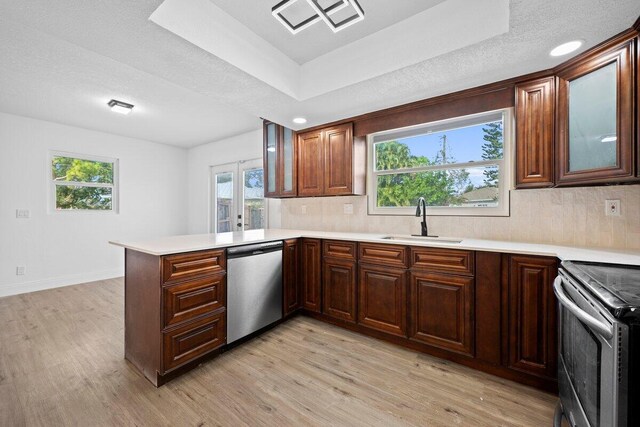 kitchen with dark brown cabinetry, stainless steel appliances, tasteful backsplash, light hardwood / wood-style floors, and a textured ceiling