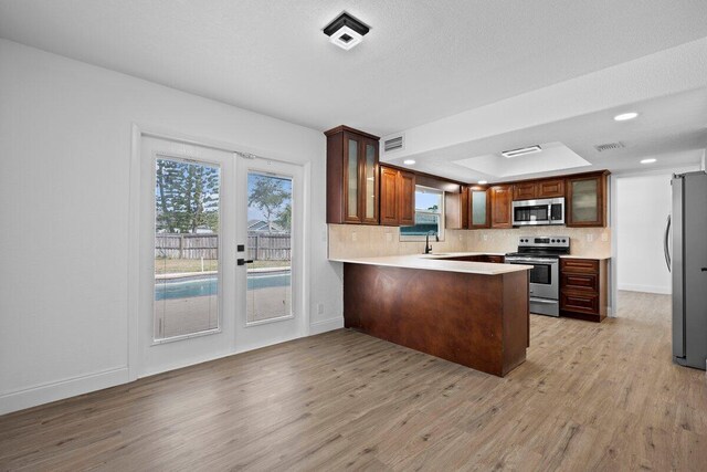 corridor featuring french doors, wood-type flooring, and a textured ceiling