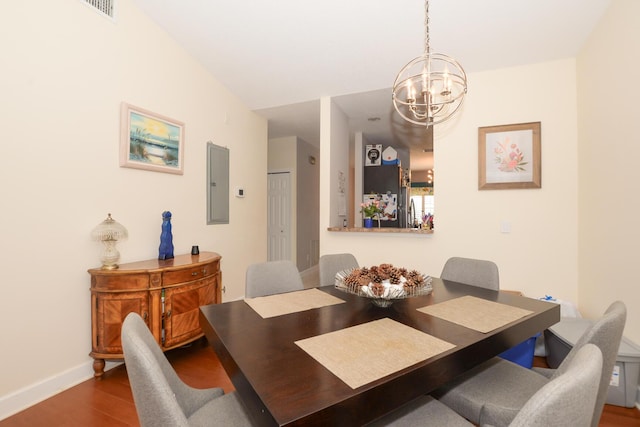 dining space featuring wood-type flooring, electric panel, and an inviting chandelier