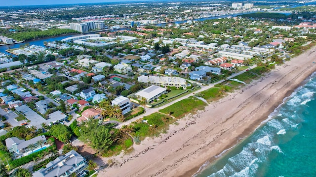 birds eye view of property with a water view and a beach view