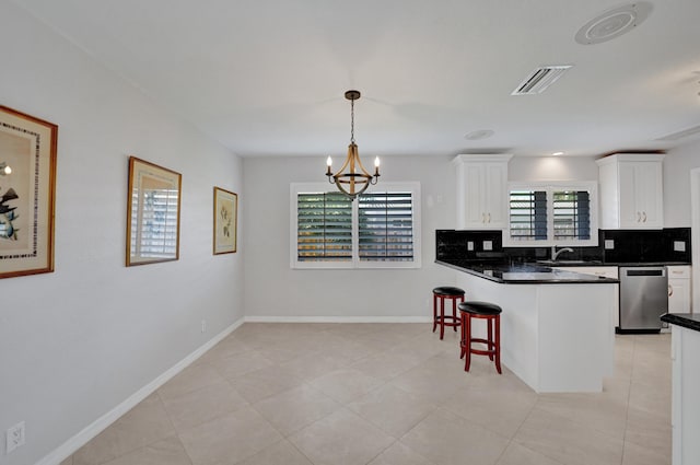 kitchen with white cabinetry, hanging light fixtures, stainless steel dishwasher, and an inviting chandelier