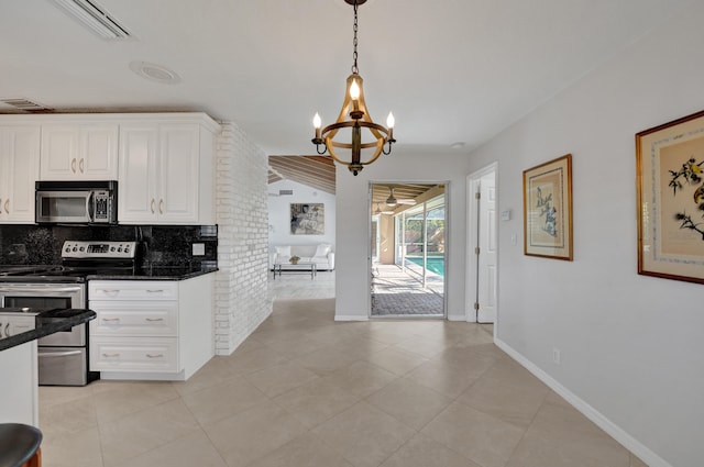 kitchen with appliances with stainless steel finishes, backsplash, decorative light fixtures, white cabinets, and a chandelier