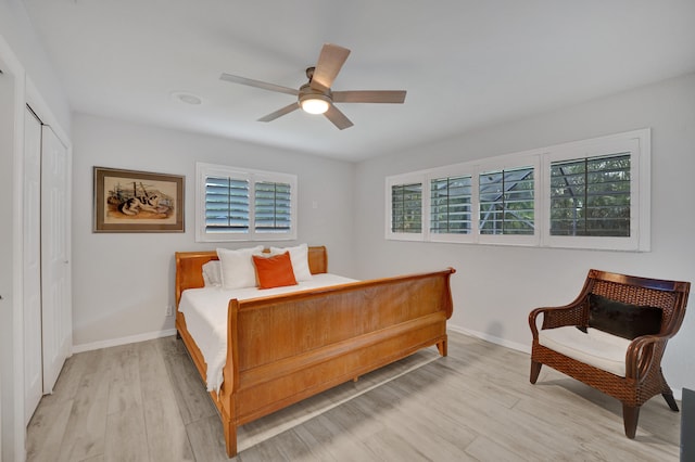 bedroom with a closet, light hardwood / wood-style flooring, and ceiling fan