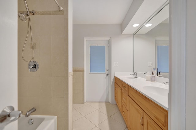 bathroom with tile patterned floors, vanity, and tiled shower / bath