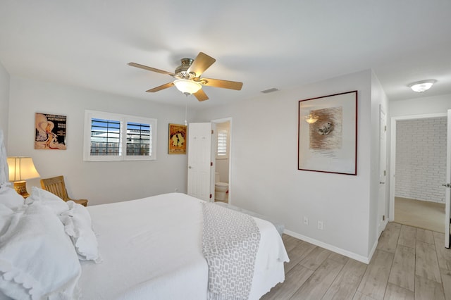 bedroom featuring ensuite bathroom, light hardwood / wood-style flooring, and ceiling fan