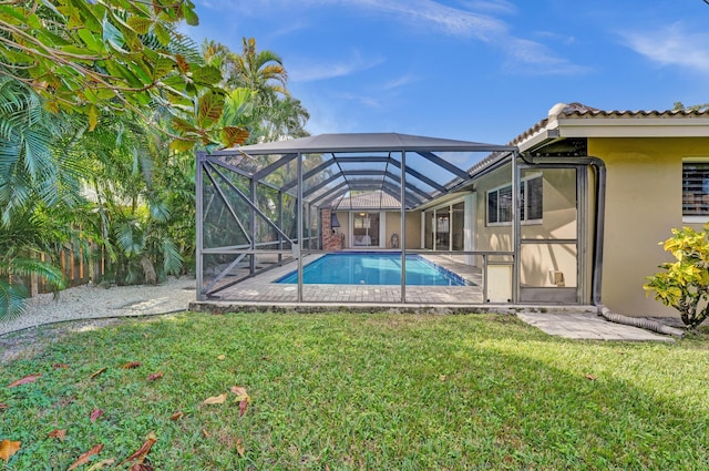 view of pool with glass enclosure and a yard