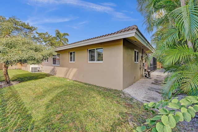 view of side of property with a yard and central AC unit