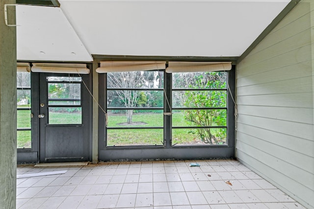 unfurnished sunroom featuring vaulted ceiling