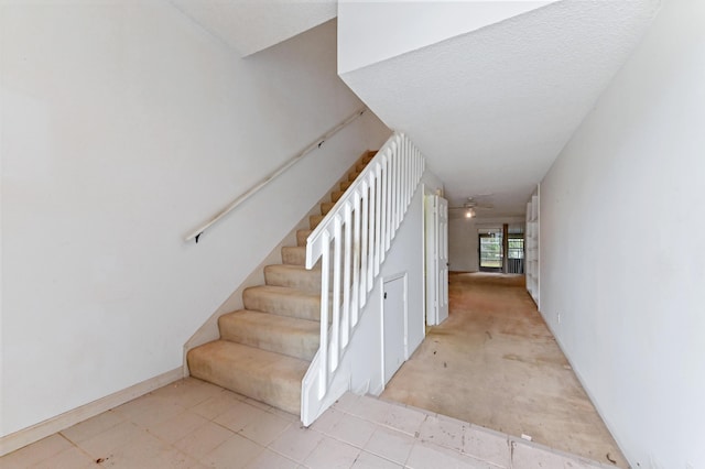 stairs featuring a textured ceiling