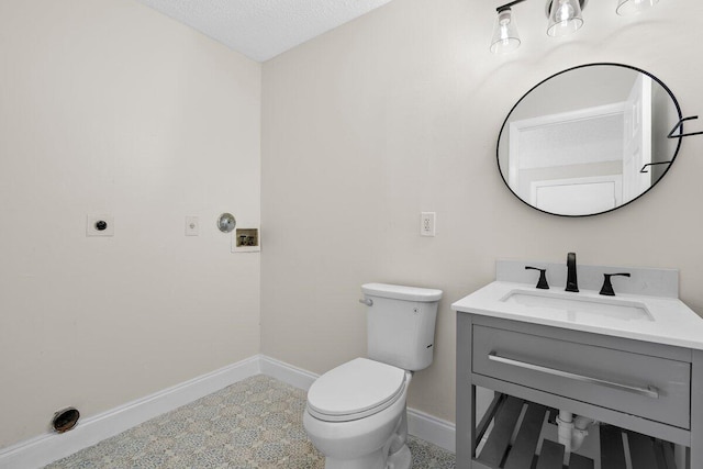 bathroom featuring vanity, a textured ceiling, and toilet