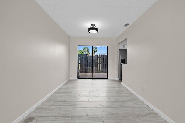 unfurnished room featuring a textured ceiling