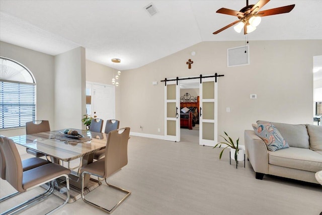 dining room with a barn door, ceiling fan, and vaulted ceiling