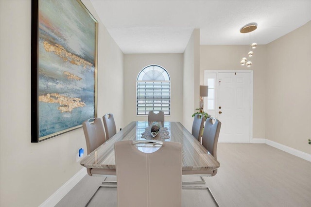 dining space featuring light carpet