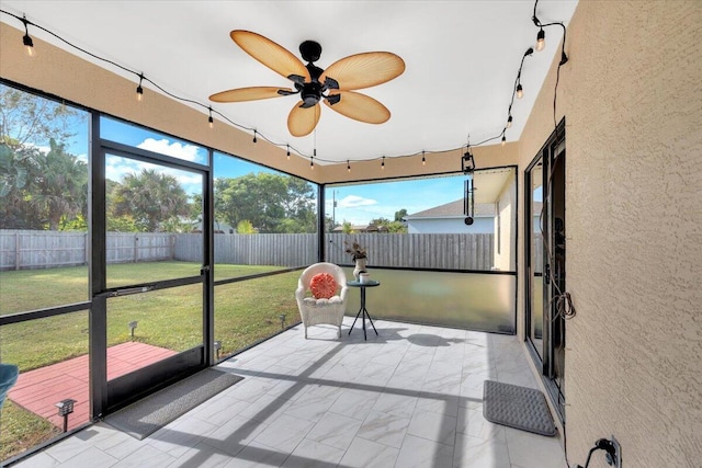 unfurnished sunroom featuring ceiling fan