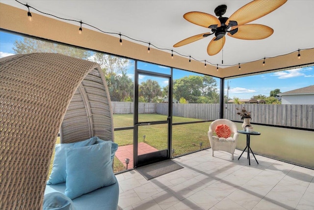 unfurnished sunroom featuring ceiling fan