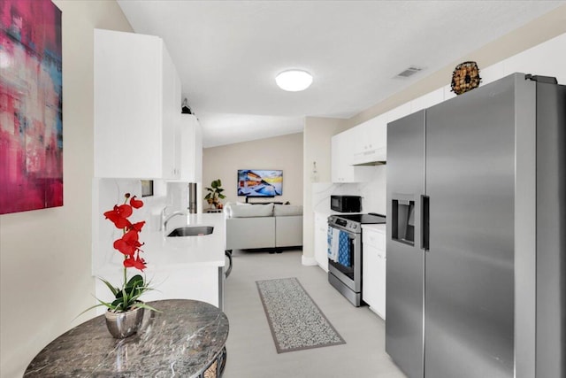 kitchen with decorative backsplash, appliances with stainless steel finishes, vaulted ceiling, sink, and white cabinetry