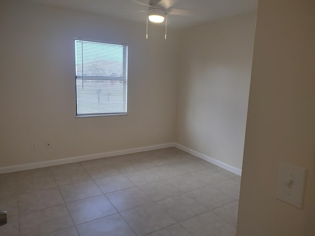 tiled empty room featuring ceiling fan