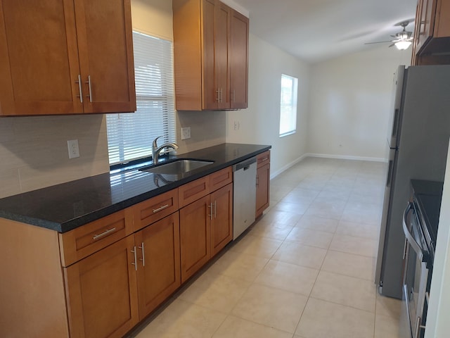 kitchen with ceiling fan, dark stone countertops, sink, and stainless steel appliances