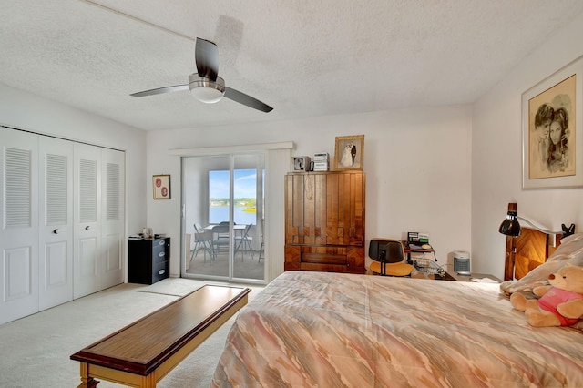 bedroom with access to exterior, ceiling fan, light colored carpet, a textured ceiling, and a closet