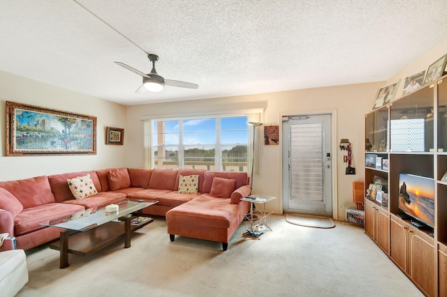 living room featuring ceiling fan, light colored carpet, and a textured ceiling