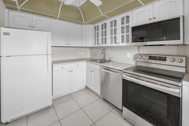 kitchen featuring light tile patterned floors, stainless steel appliances, white cabinetry, and sink