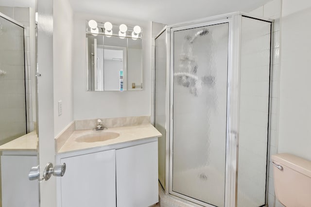 bathroom with vanity, toilet, and an enclosed shower