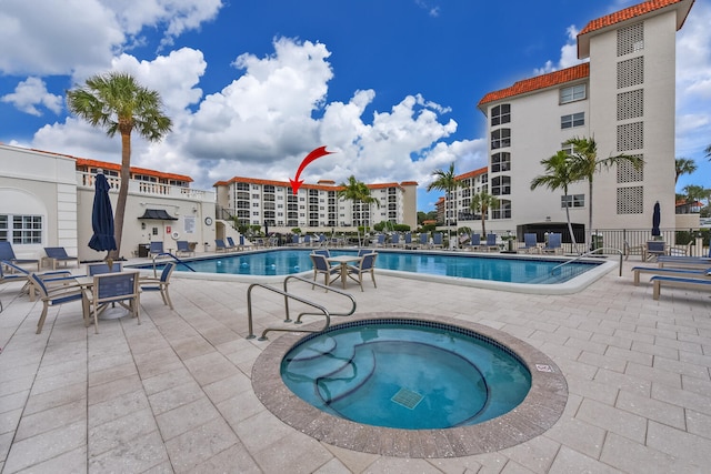 view of swimming pool with a community hot tub and a patio